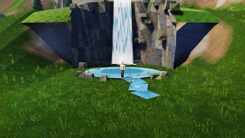A waterfall pours into a clear pool in a hillside, and the man stands in the pool.